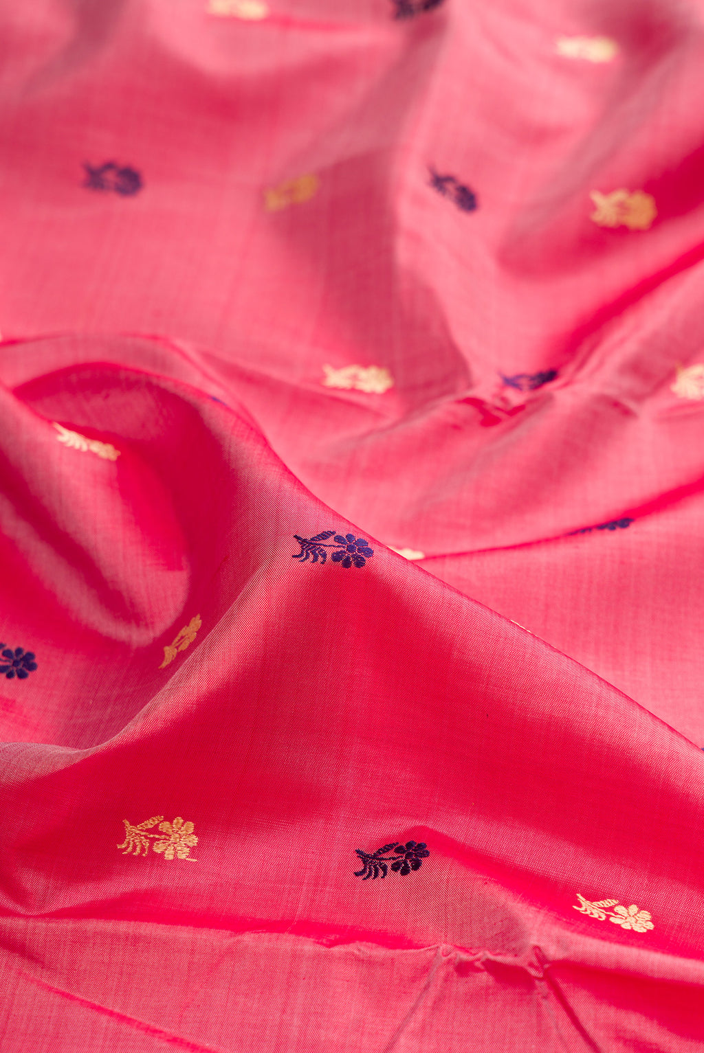 Close up of Coral Baluchari Silk Saree with Thread Butta on the body and Thread Border.  displaying folds