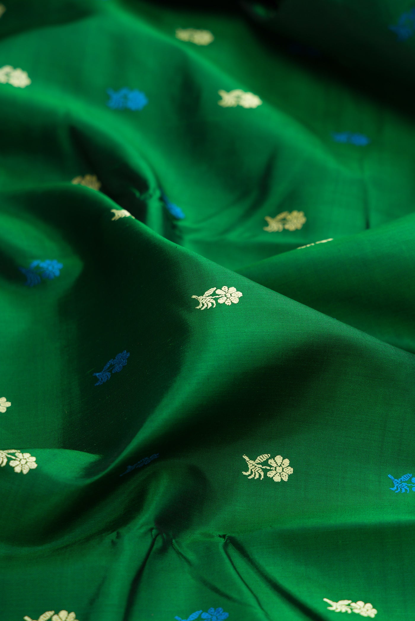 Close up of Green Baluchari Silk Saree with Thread Butta on the body and Thread Border.  displaying folds