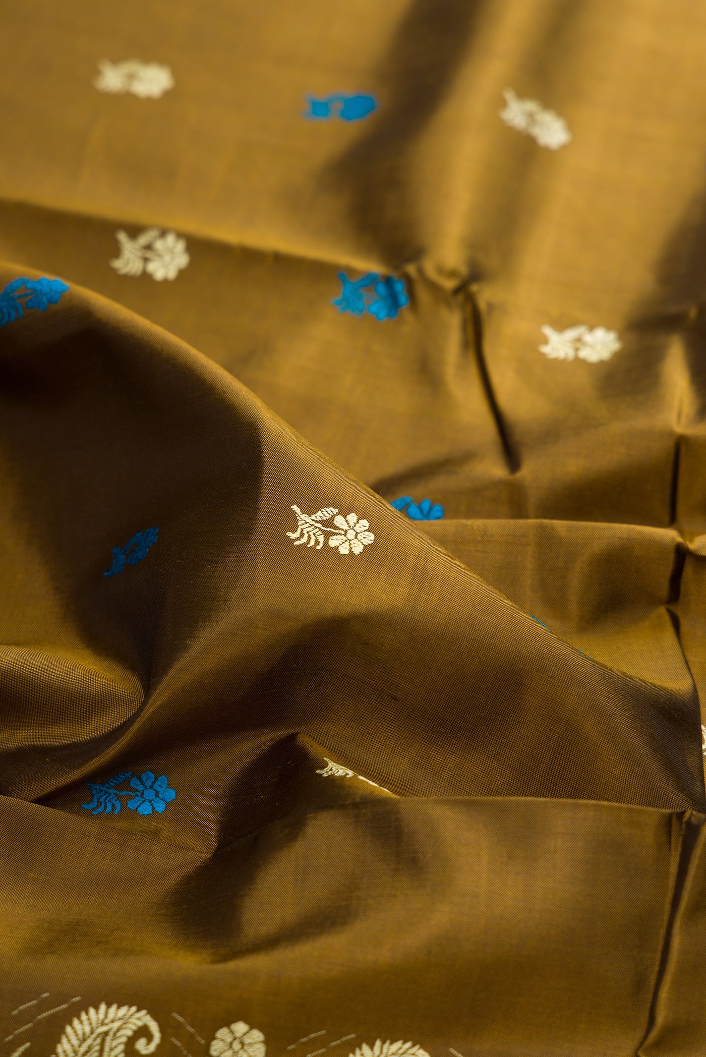 Close up of Mehandi Green Baluchari Silk Saree with Thread Butta on the body and Thread Border.  displaying folds