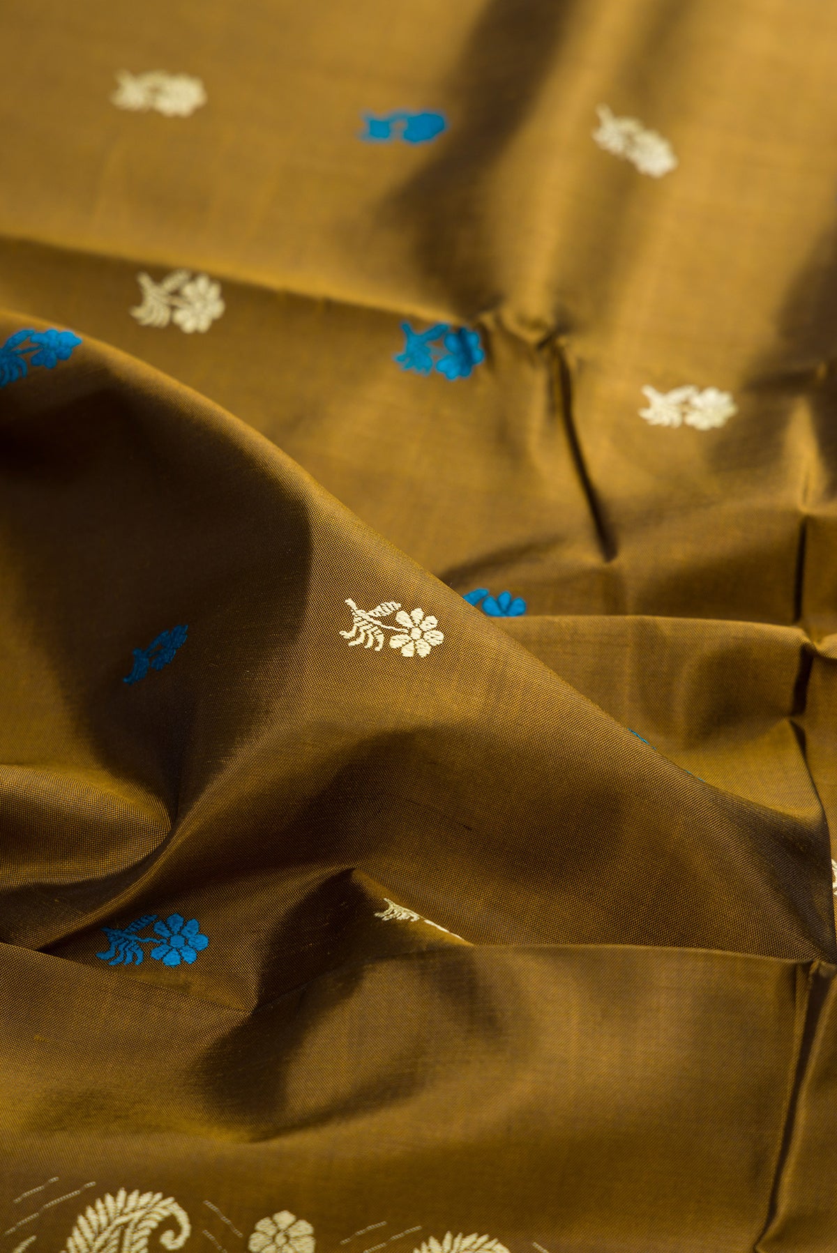 Close up of Mehandi Green Baluchari Silk Saree with Thread Butta on the body and Thread Border.  displaying folds