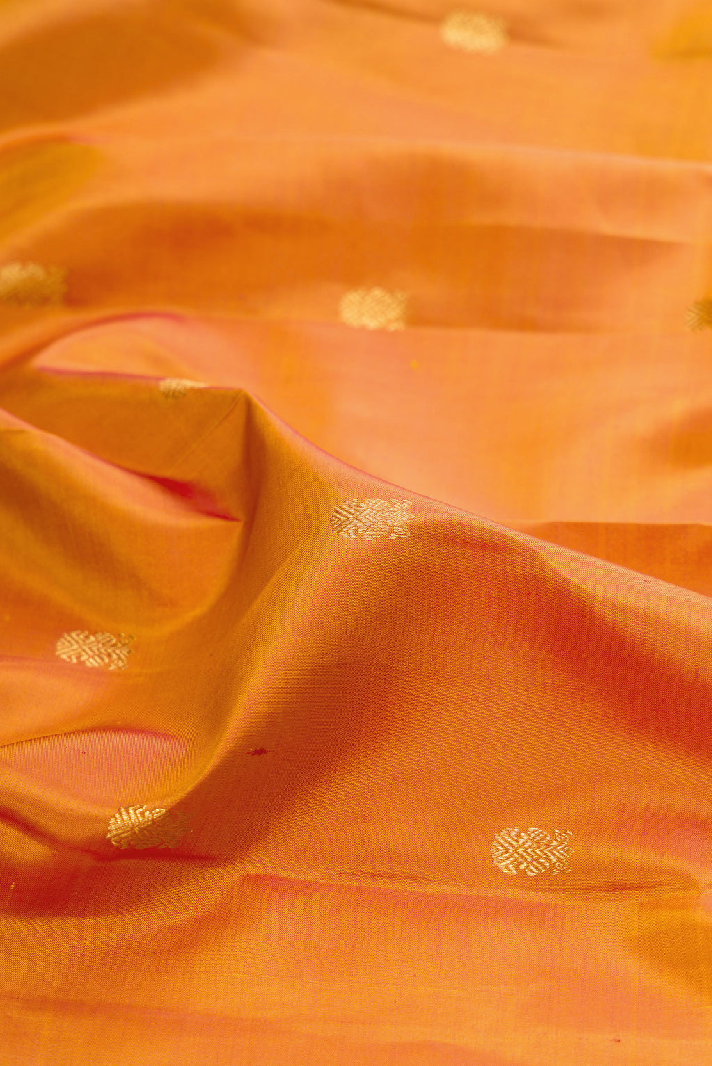 Close up of Mustard Dual Tone Kanjivaram Silk Saree with Zari Butta on the body and Zari Border.  displaying folds