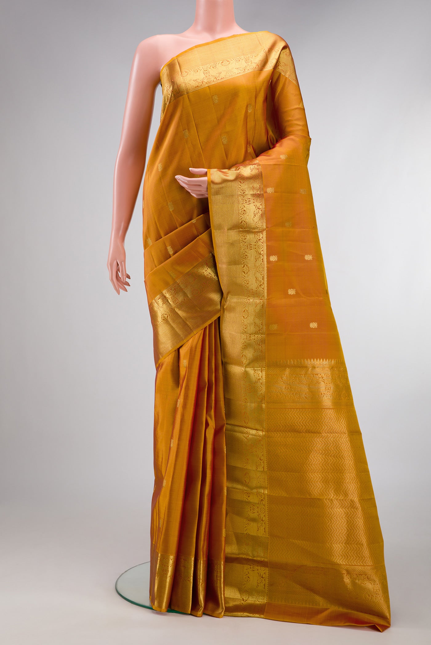 Mustard Dual Tone Kanjivaram Silk Saree with Zari Butta on the body and Zari Border.  displayed on a mannequin