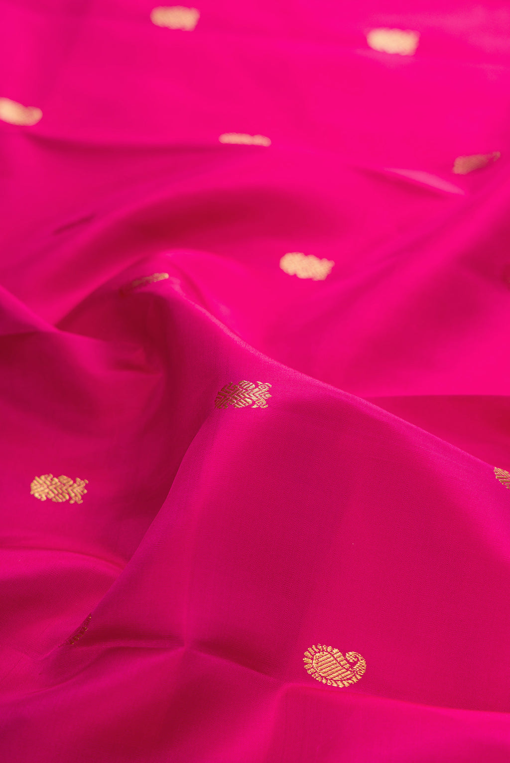 Close up of Pure Silk Pink Kanjivaram Saree with Zari Butta on the body and Zari Border.  displaying folds