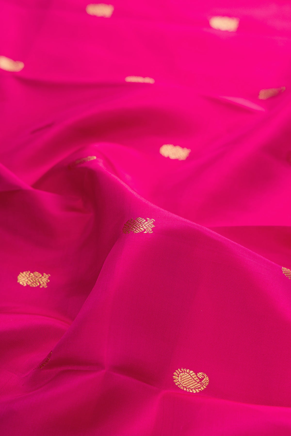 Close up of Pure Silk Pink Kanjivaram Saree with Zari Butta on the body and Zari Border.  displaying folds