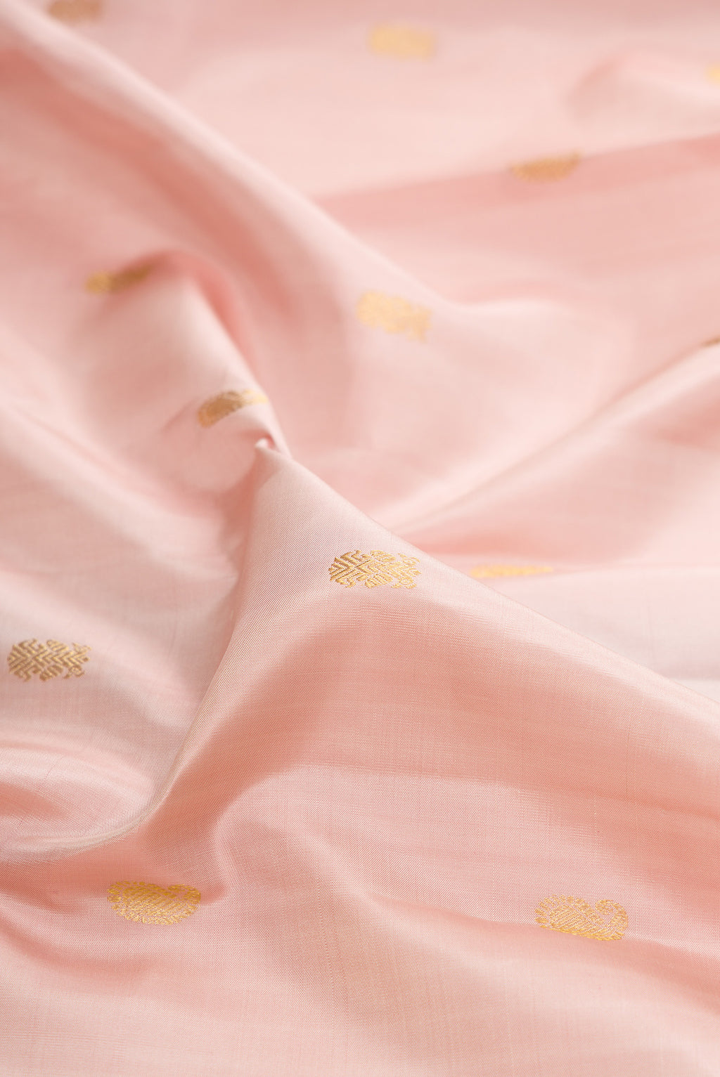 Close up of Pure Silk Rose pink Kanjivaram Saree with Zari Butta on the body and Zari Border.  displaying folds