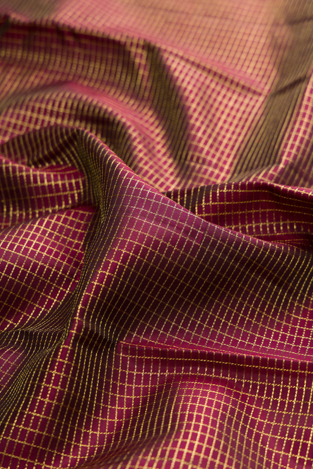 Close up of Pure Silk Maroon Kanchipuram Saree with Checked design on the body and Zari Border.  displaying folds