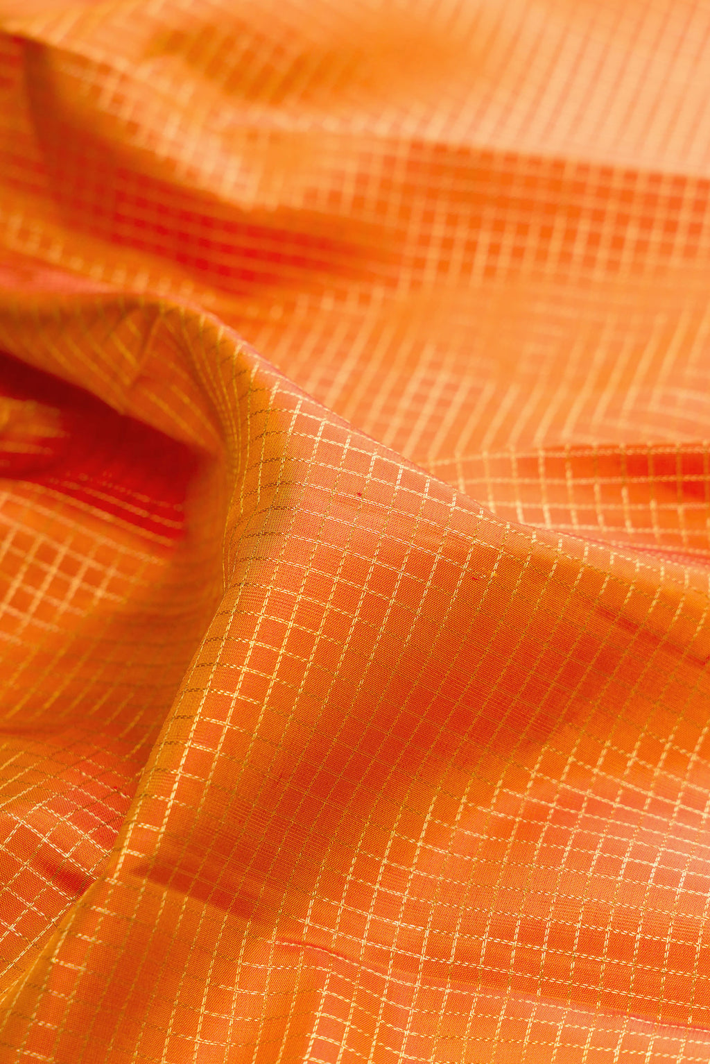 Close up of Pure Silk Mustard Dual Tone Kanchipuram Saree with Checked design on the body and Zari Border.  displaying folds