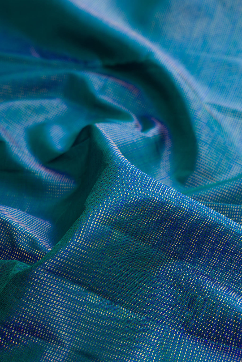 Close up of Pure Silk Peacock Blue Dual Tone Kanchipuram Saree with Checked design on the body and Zari Border.  displaying folds