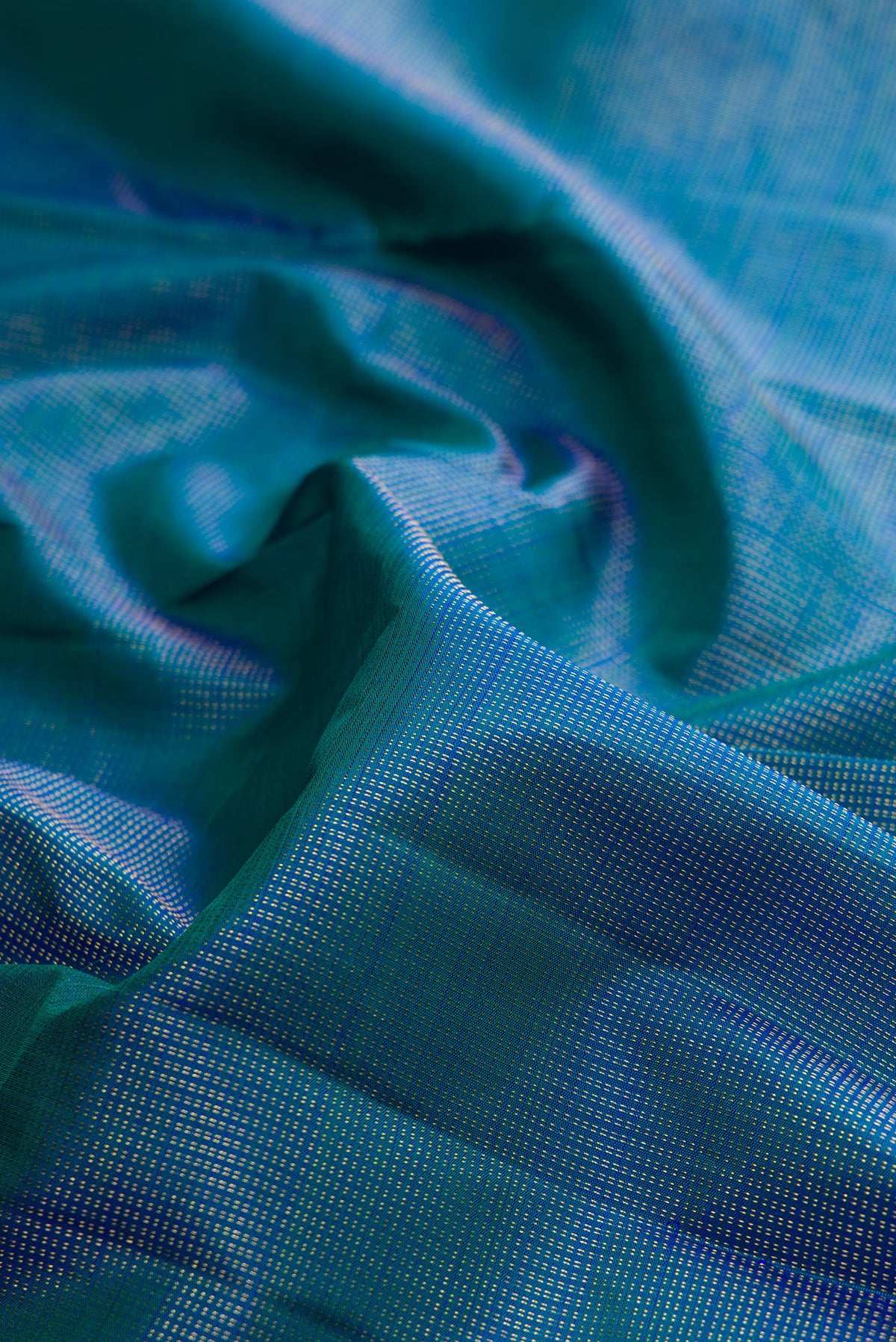 Close up of Pure Silk Peacock Blue Dual Tone Kanchipuram Saree with Checked design on the body and Zari Border.  displaying folds