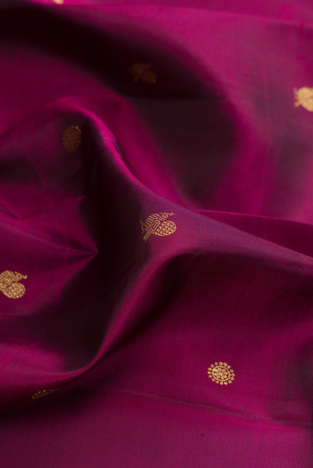 Close up of Pure Silk Maroon Kanchipuram Saree with Zari Butta on the body and Zari Border.  displaying folds