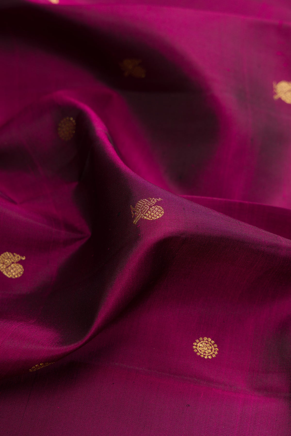 Close up of Pure Silk Maroon Kanchipuram Saree with Zari Butta on the body and Zari Border.  displaying folds