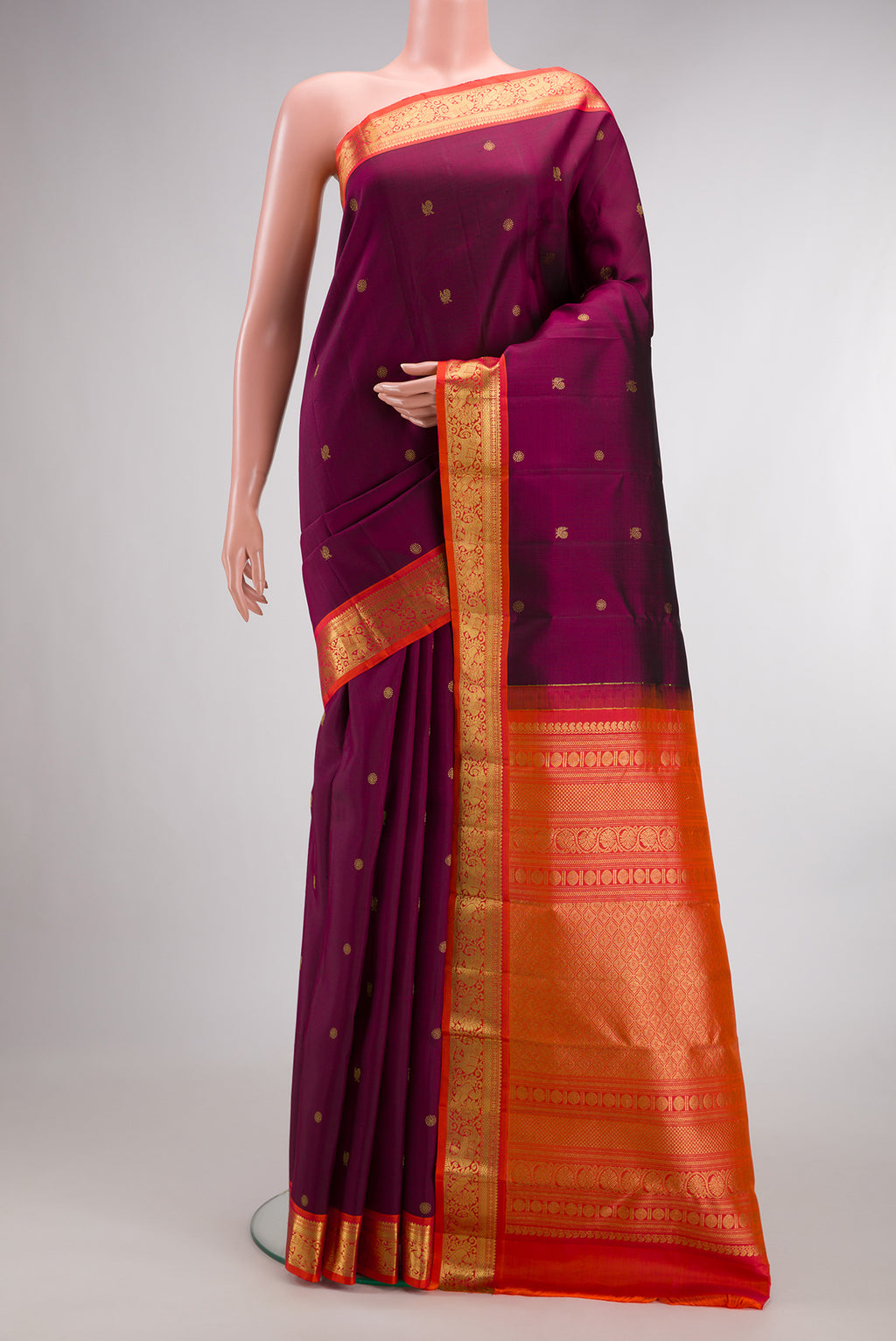 Pure Silk Maroon Kanchipuram Saree with Zari Butta on the body and Zari Border.  displayed on a mannequin