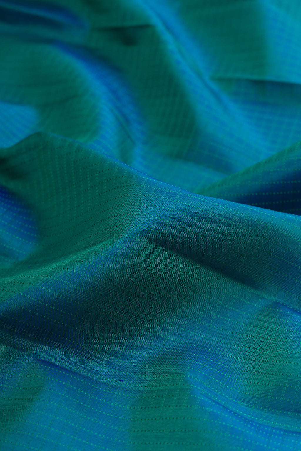 Close up of Pure Silk Peacock Blue Kanchipuram Saree with Checked design on the body and Zari Border.  displaying folds