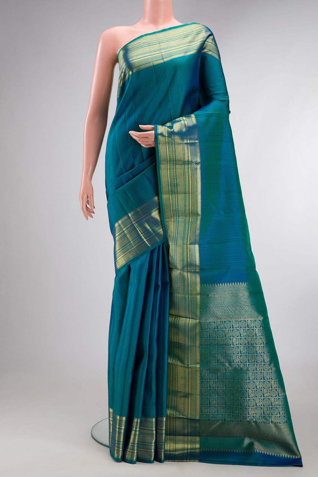 Pure Silk Peacock Blue Kanchipuram Saree with Checked design on the body and Zari Border.  displayed on a mannequin