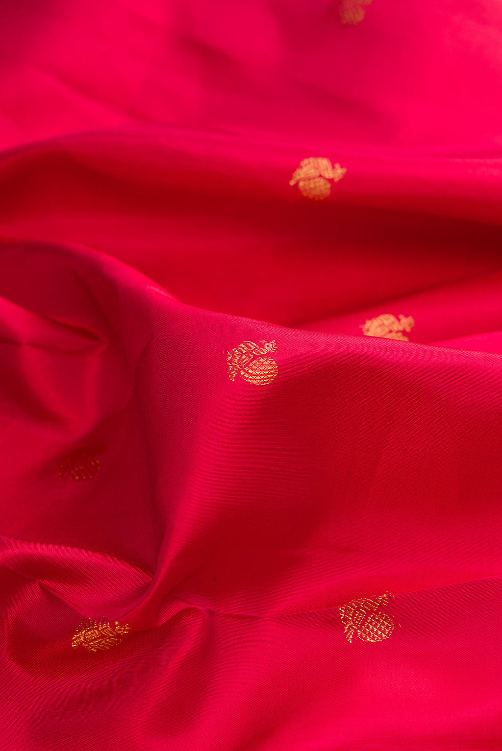 Close up of Pure Silk Red Kanchipuram Saree with Zari Butta on the body and Fancy Border.  displaying folds