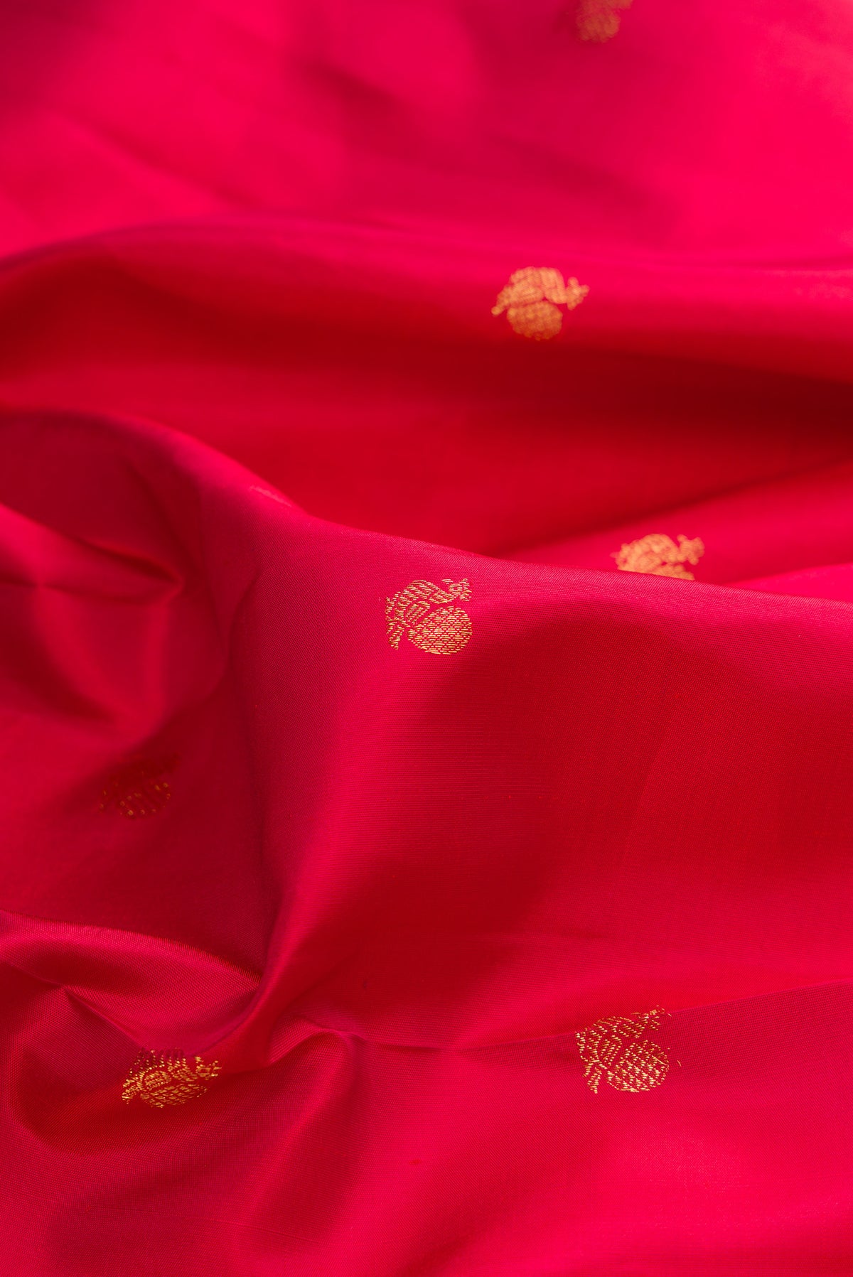 Close up of Pure Silk Red Kanchipuram Saree with Zari Butta on the body and Fancy Border.  displaying folds