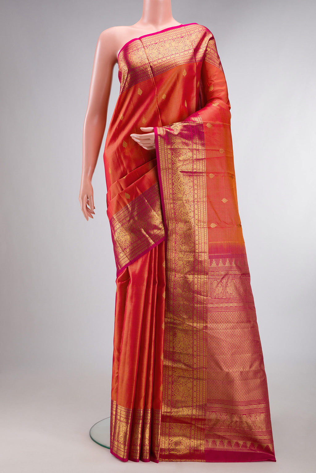 Pure Silk Coral Dual Tone Kanchipuram Saree with Zari Butta on the body and Zari Border.  displayed on a mannequin