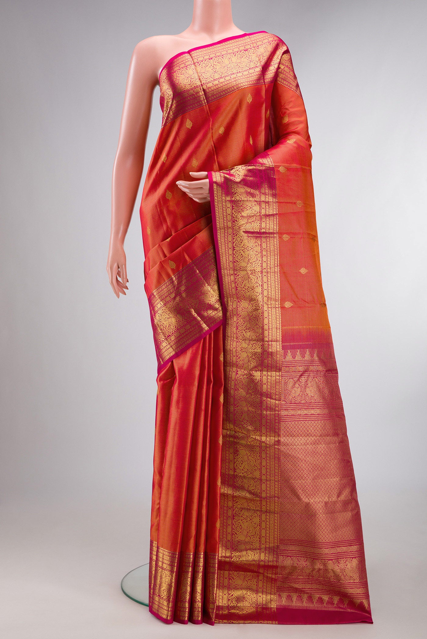Pure Silk Coral Dual Tone Kanchipuram Saree with Zari Butta on the body and Zari Border.  displayed on a mannequin