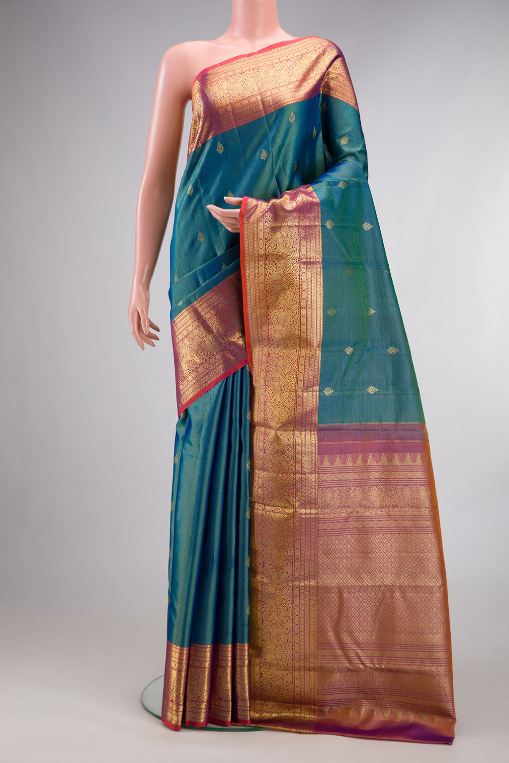 Pure Silk Peacock Blue Dual Tone Kanchipuram Saree with Stripes on the body and Zari Border.  displayed on a mannequin