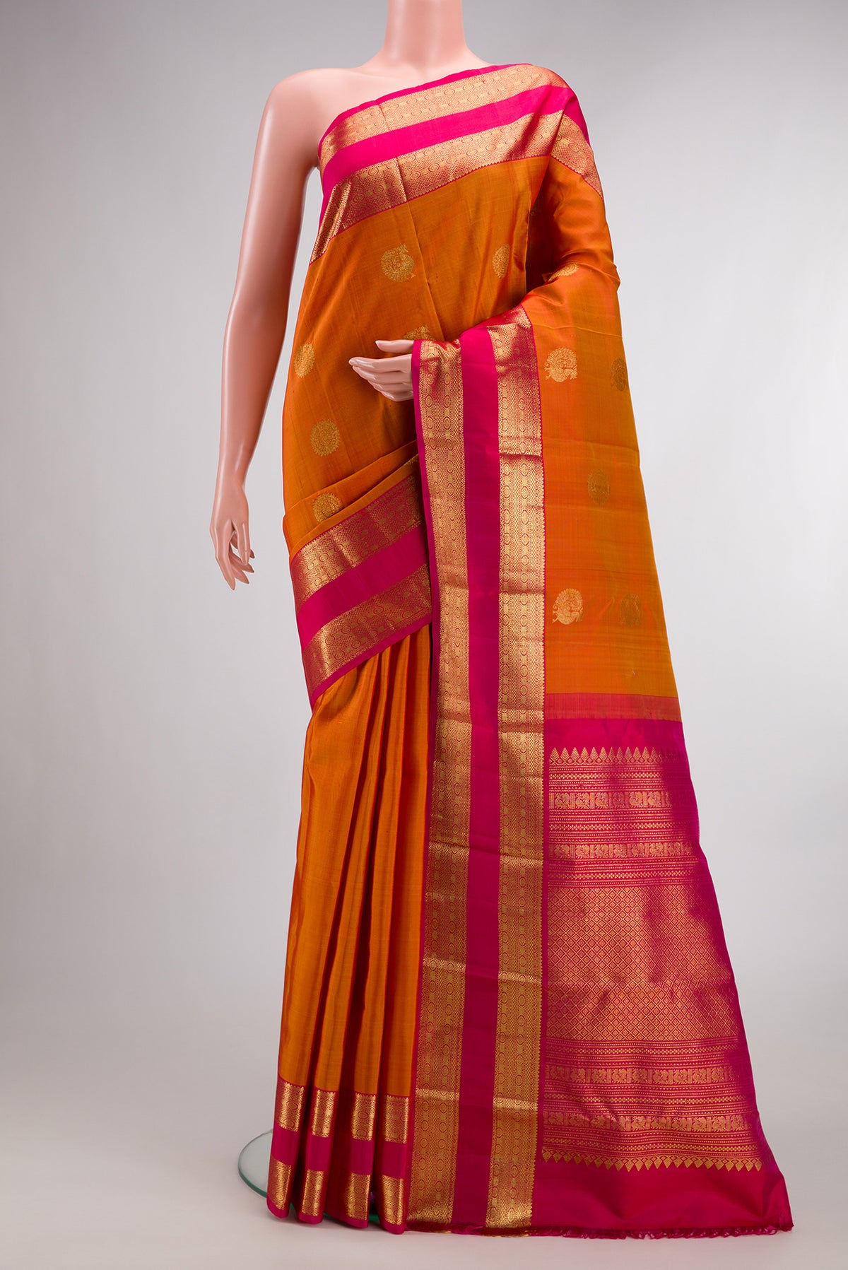Pure Silk Mustard Kanchipuram Saree with Zari Butta on the body and Zari Border.  displayed on a mannequin