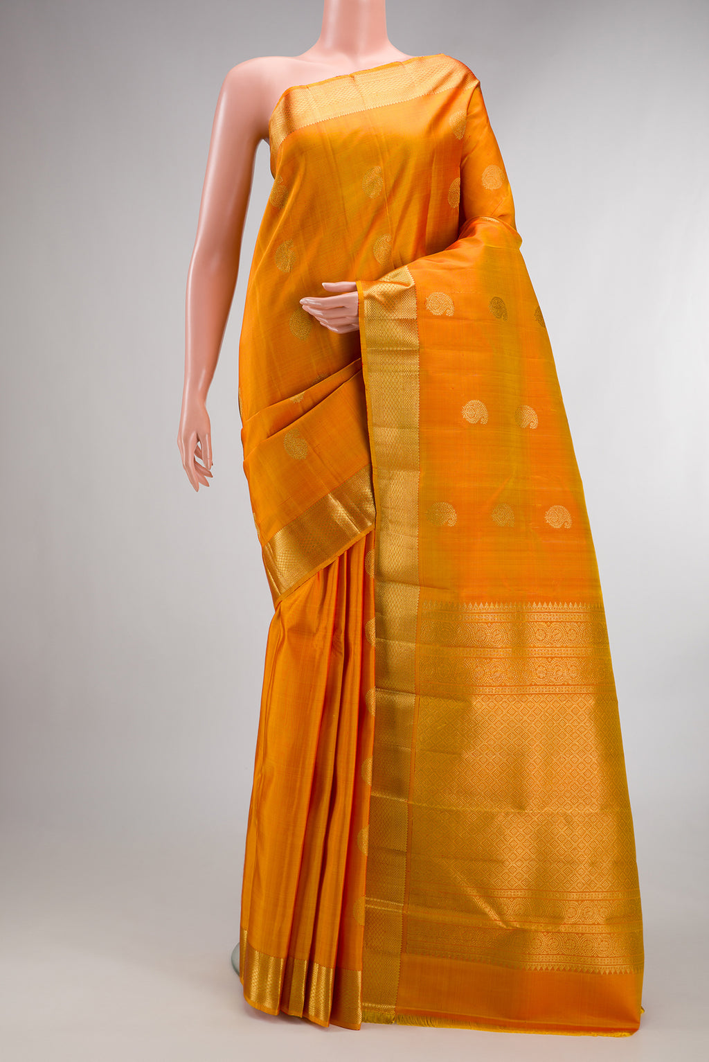 Pure Silk Mustard Kanchipuram Saree with Zari Butta on the body and Zari Border.  displayed on a mannequin
