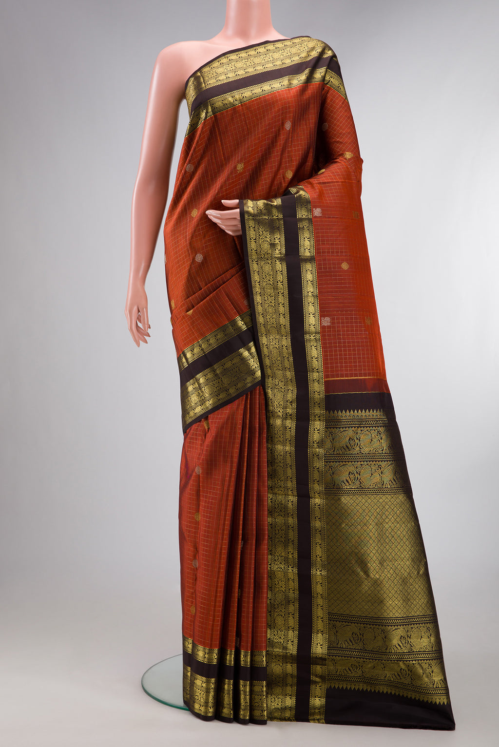 Pure Silk Rust Kanchipuram Saree with Checked design on the body and Zari Border.  displayed on a mannequin