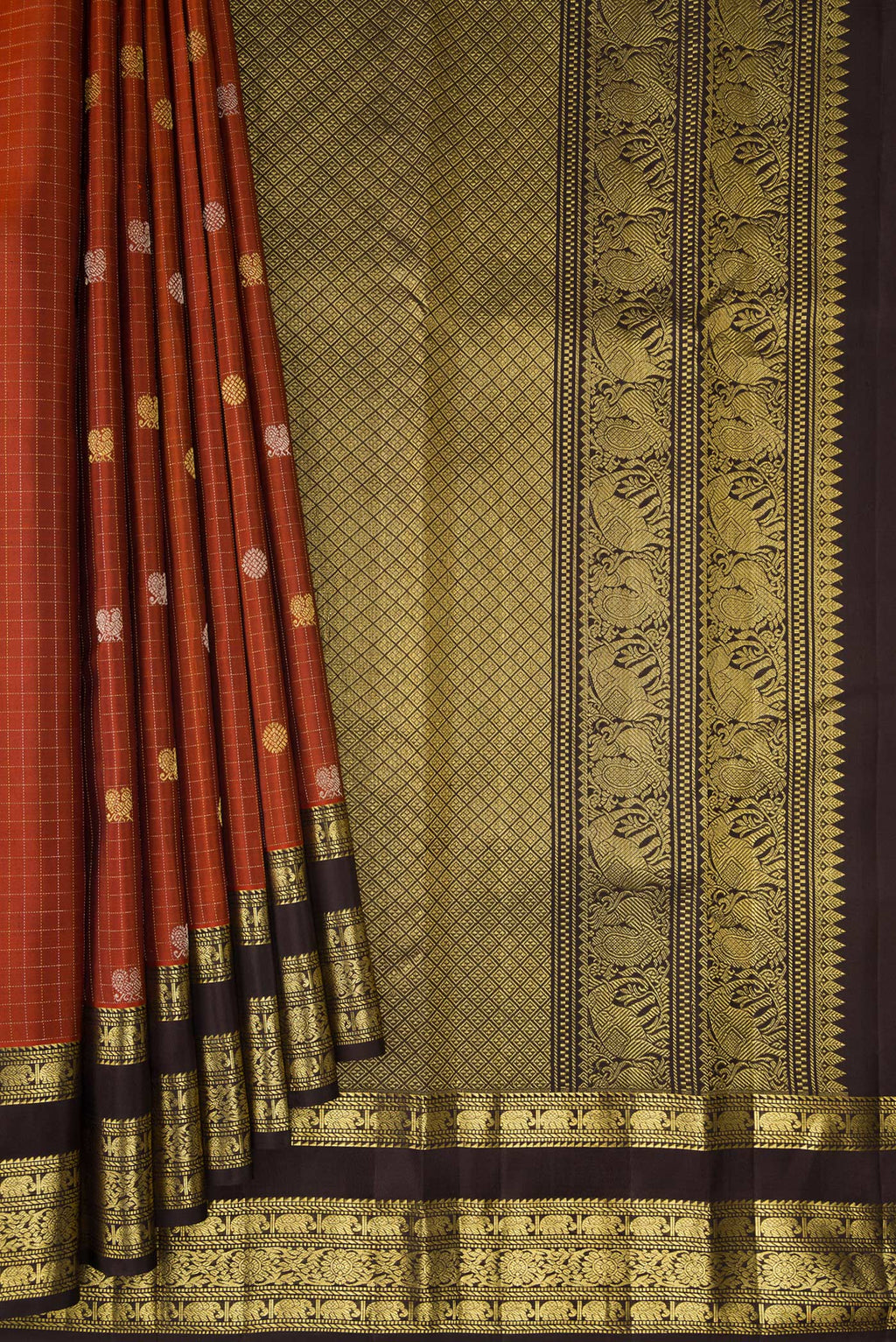 Pleats and pallu of Pure Silk Rust Kanchipuram Saree with Checked design on the body and Zari Border. 