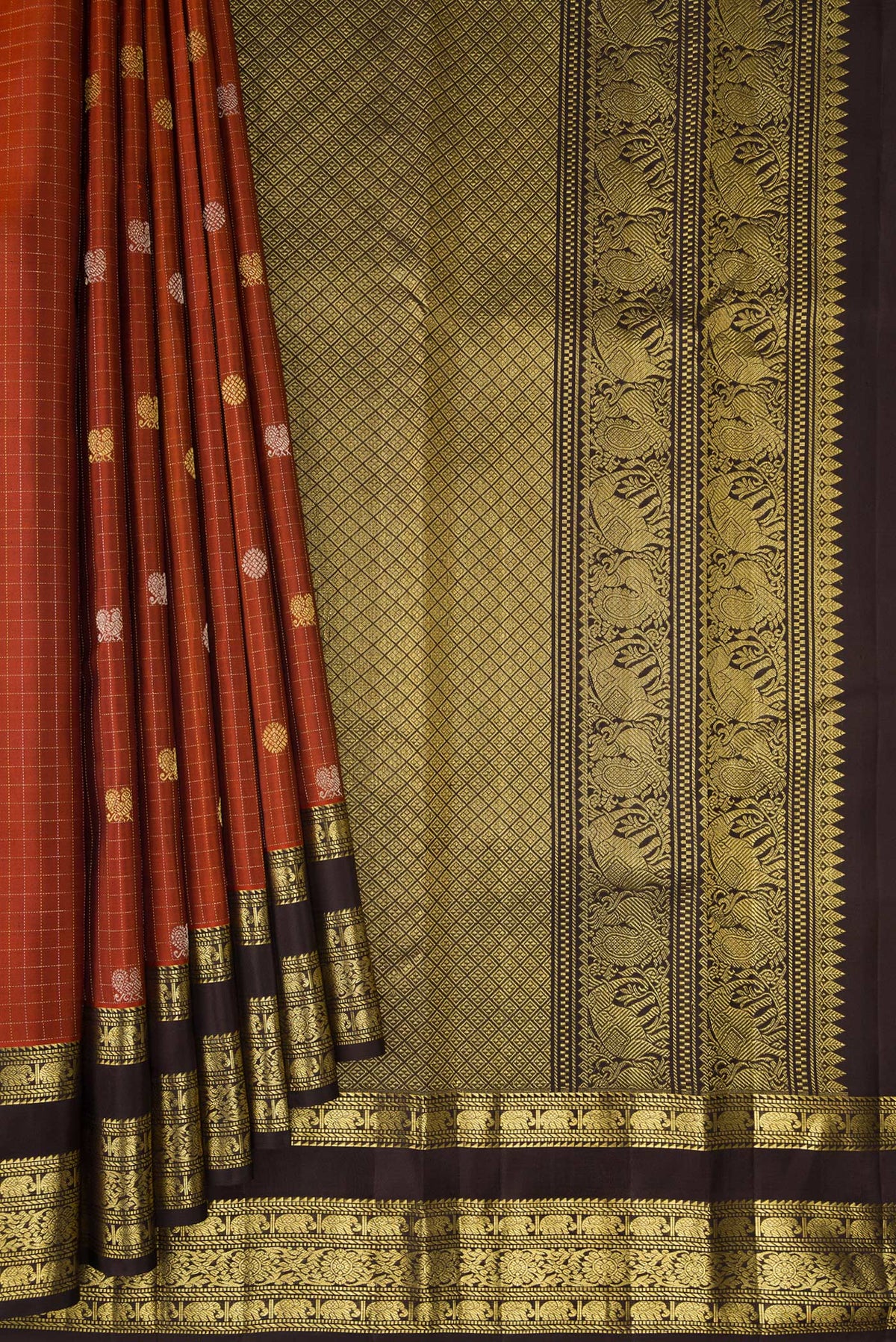 Pleats and pallu of Pure Silk Rust Kanchipuram Saree with Checked design on the body and Zari Border. 