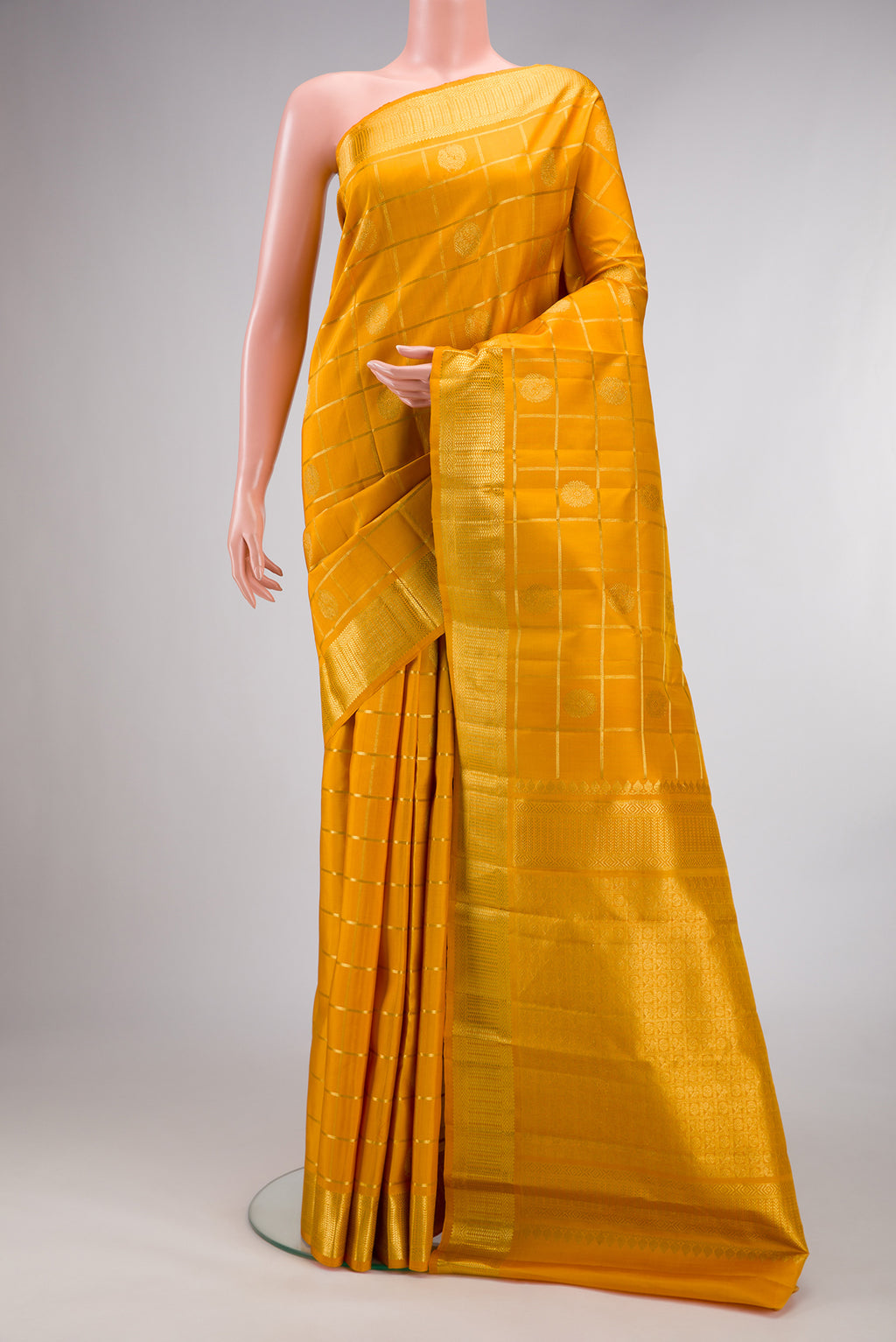 Pure Silk Mustard Kanchipuram Saree with Checked design on the body and Zari Border.  displayed on a mannequin
