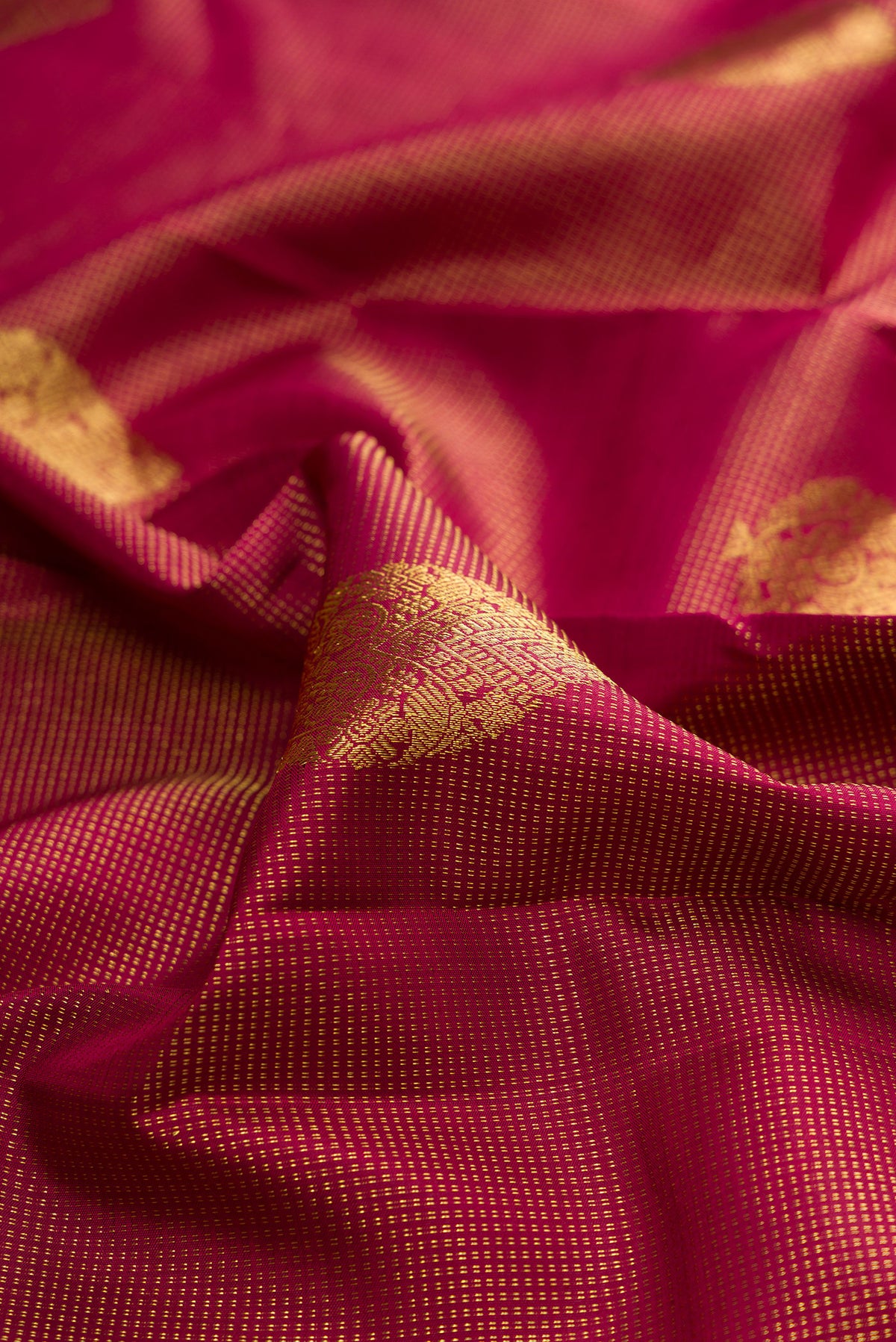 Close up of Pure Silk Maroon Kanchipuram Saree with Checked design on the body and Zari Border.  displaying folds