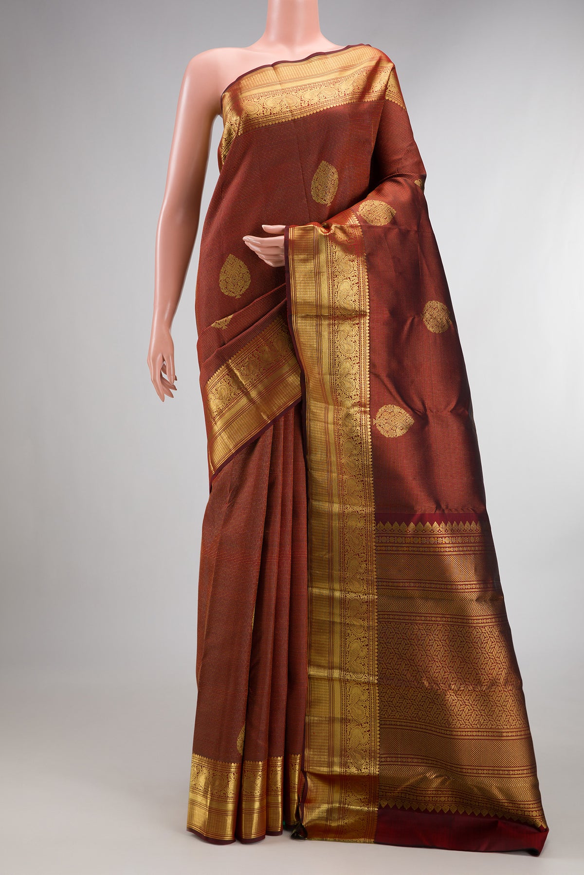 Pure Silk Maroon Kanchipuram Saree with Zari Butta on the body and Zari Border.  displayed on a mannequin