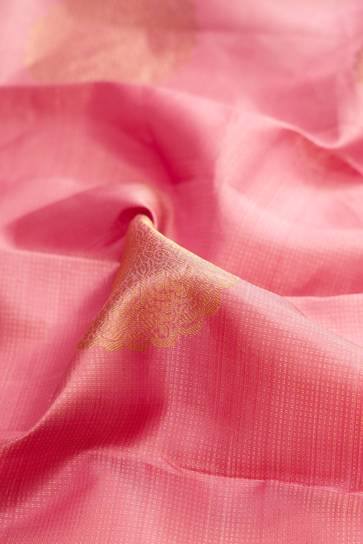 Close up of Pure Silk Coral Dual Tone Kanchipuram Saree with Zari Butta on the body and Zari Border.  displaying folds