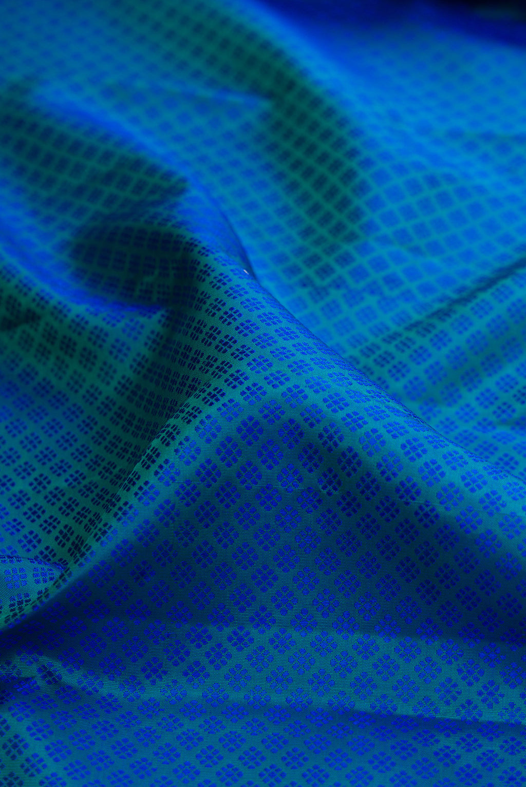 Close up of Pure Silk Peacock Blue Dual Tone Kanjivaram Saree with Jacquard design on the body and Zari Border.  displaying folds