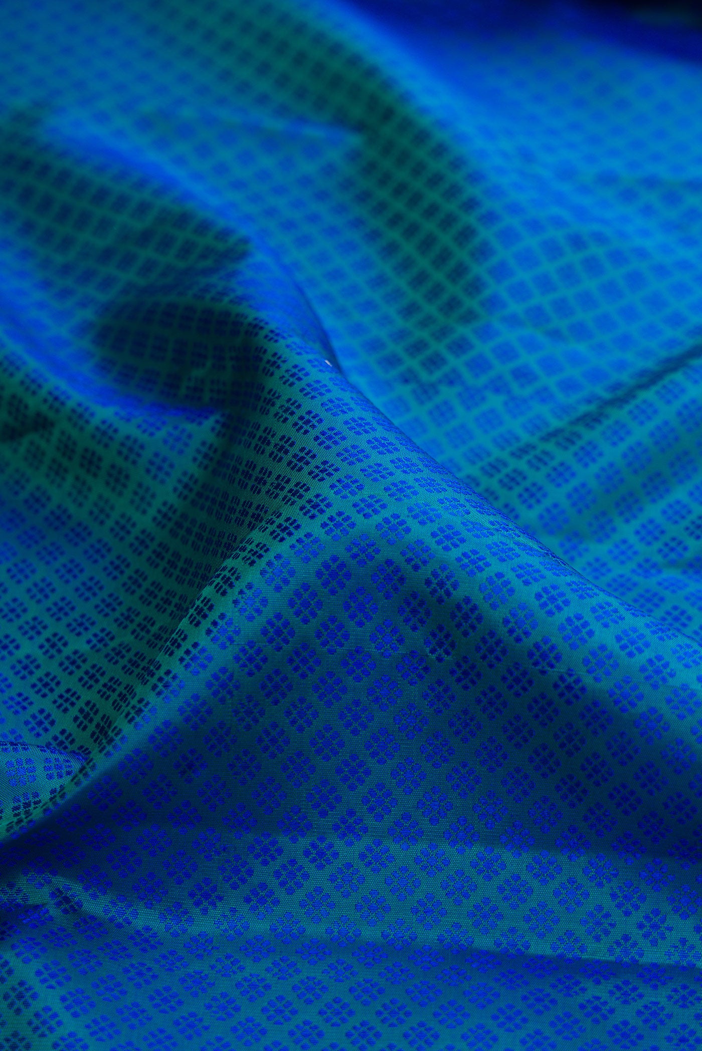 Close up of Pure Silk Peacock Blue Dual Tone Kanjivaram Saree with Jacquard design on the body and Zari Border.  displaying folds