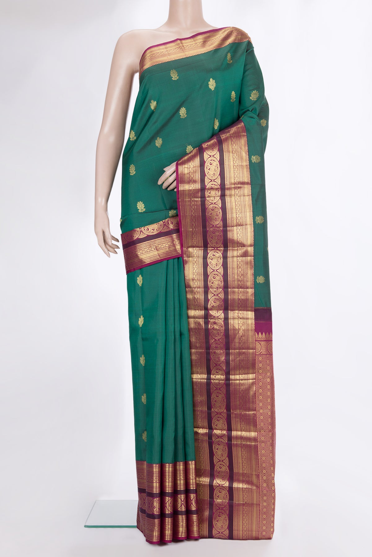 Pure Silk Bottle Green Kanjivaram Saree with Zari Butta on the body and Zari Border.  displayed on a mannequin