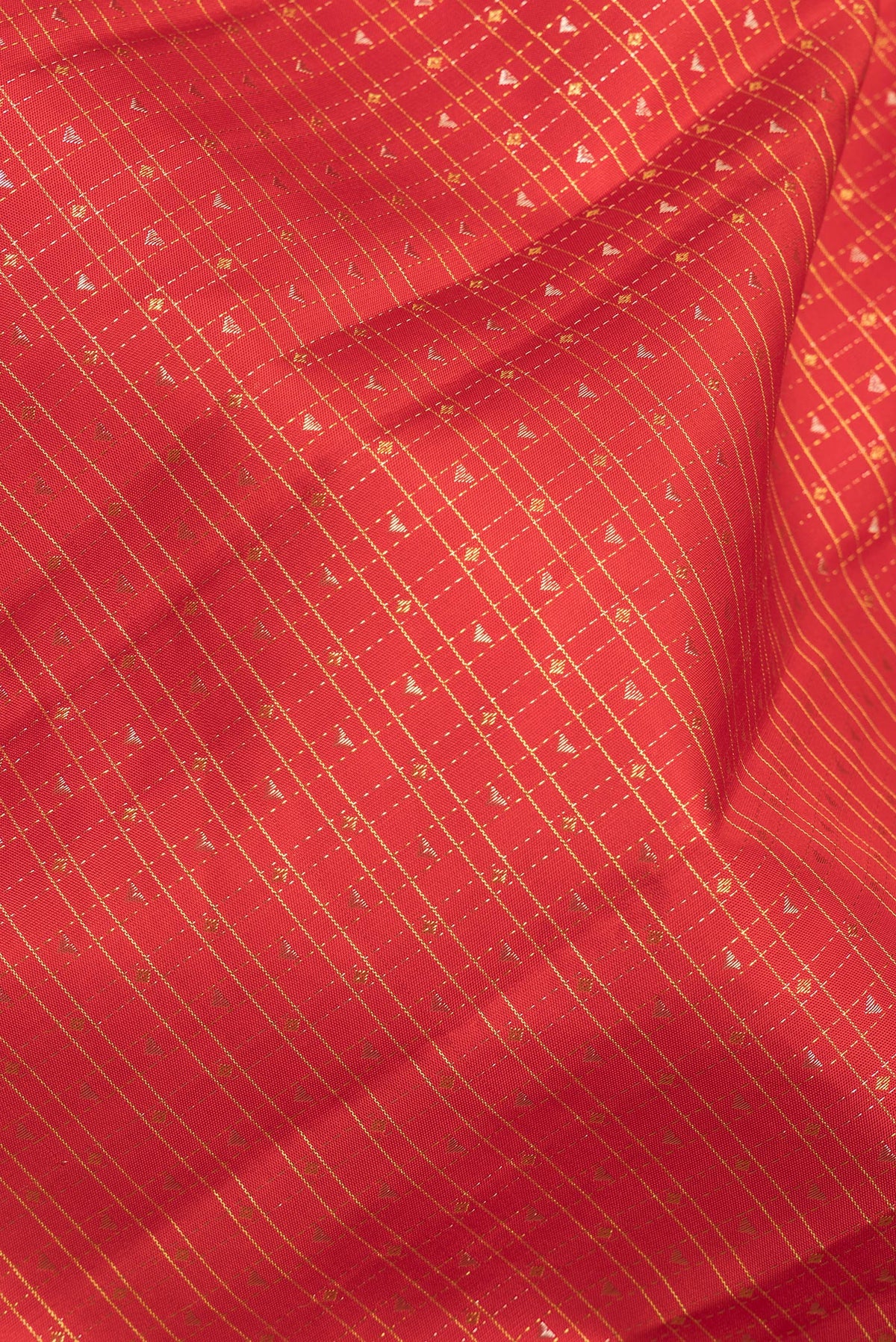 Close up of Pure Silk Orange Kanchipuram Saree with Checked design on the body and Plain Border.  displaying folds