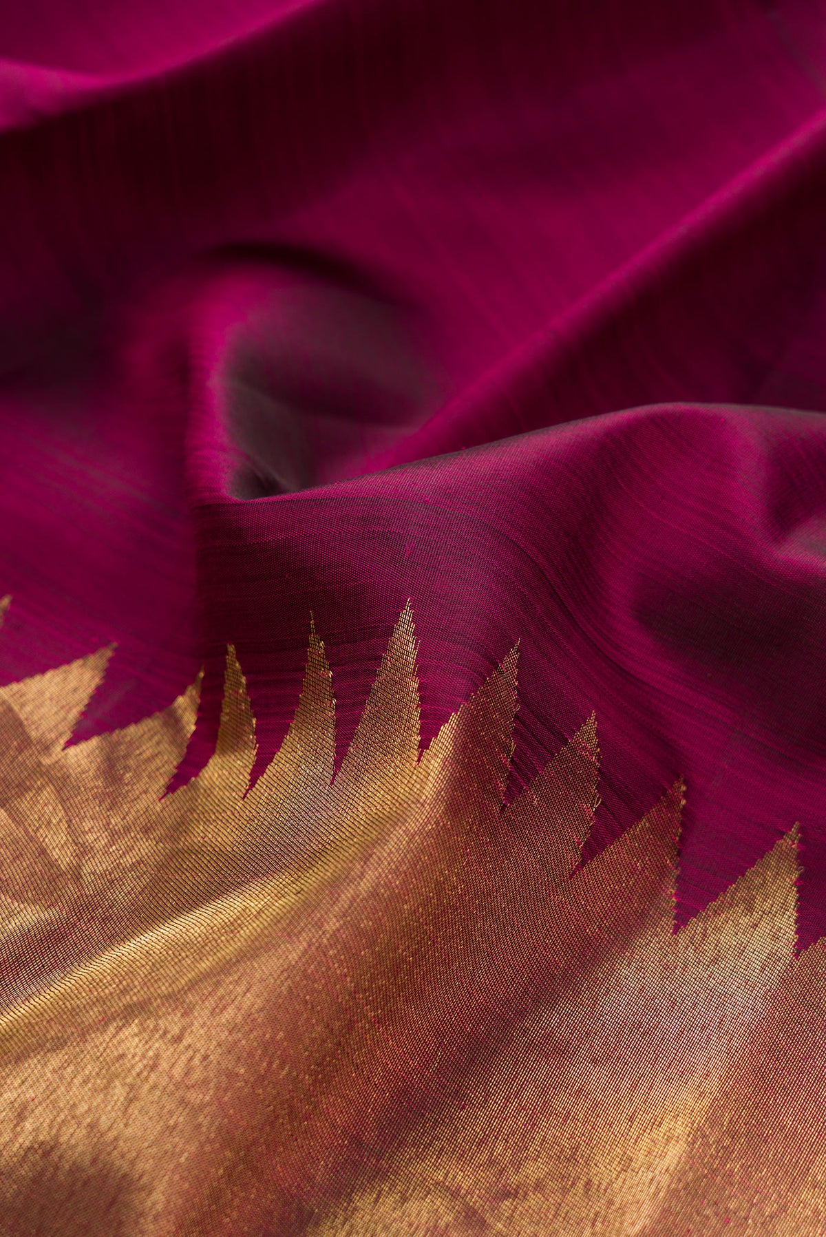 Close up of Pure Silk Maroon Kanjivaram Saree with Plain Body and Rising Temple Border.  displaying folds