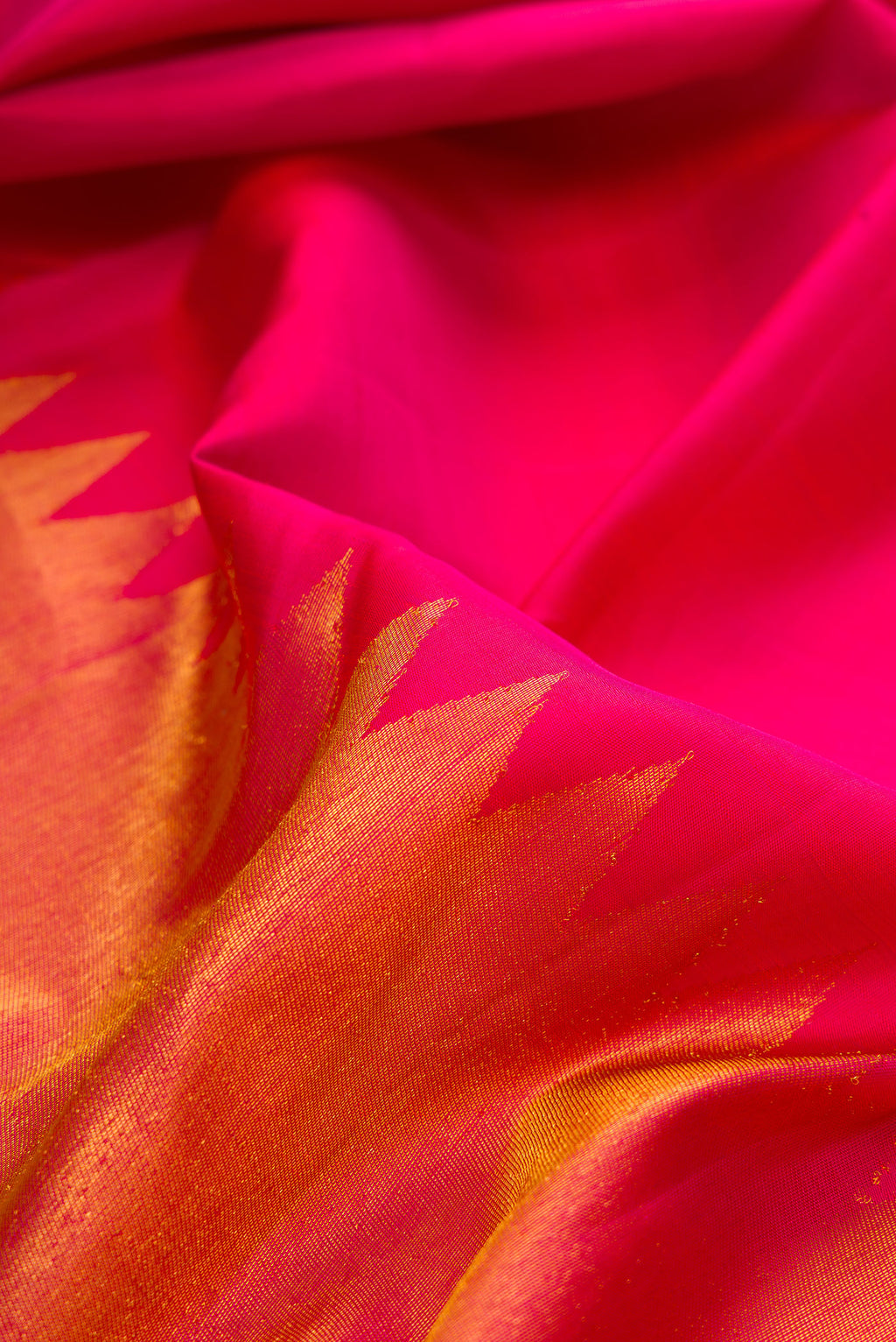 Close up of Pure Silk Dark Pink Dual Tone Kanjivaram Saree with Plain Body and Rising Temple Border.  displaying folds
