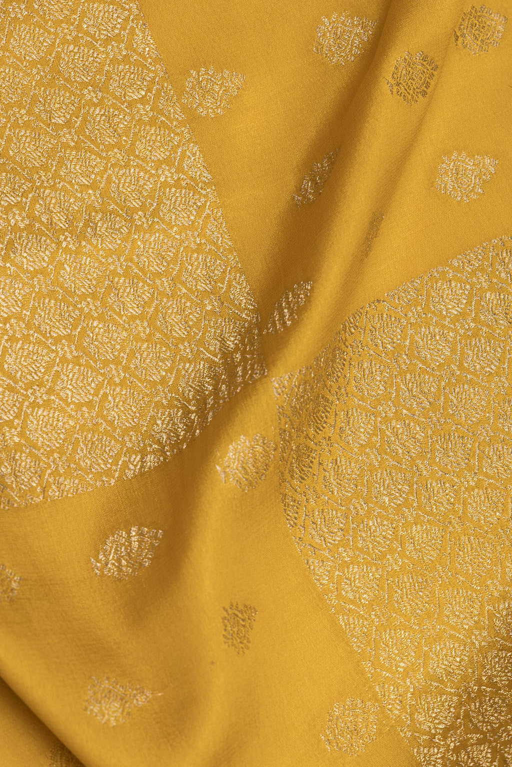 Close up of Pure Silk Mustard Dual Tone Banarasi Georgette Saree with Zari Butta on the body and Zari Border.  displaying folds
