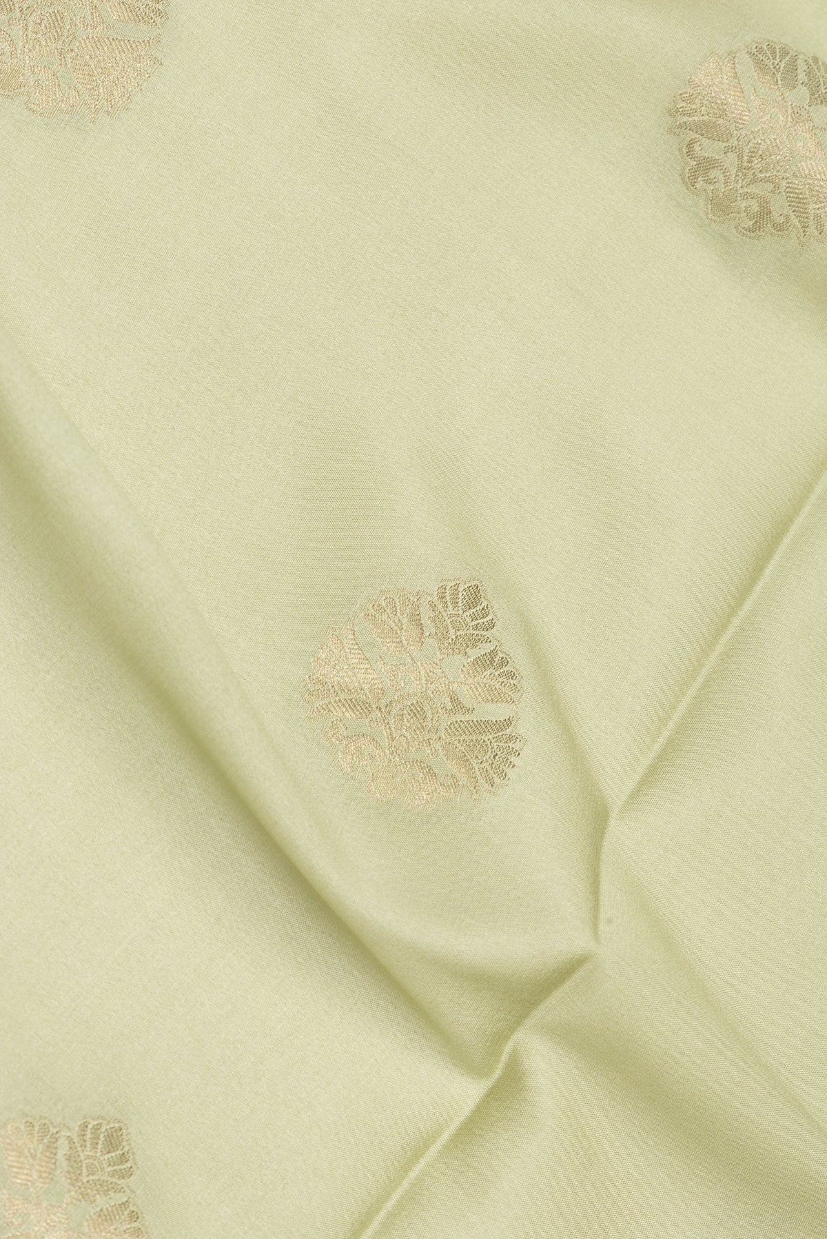 Close up of Pure Silk Pista Green Dual Tone Banarasi Georgette Saree with Zari Butta on the body and Zari Border.  displaying folds