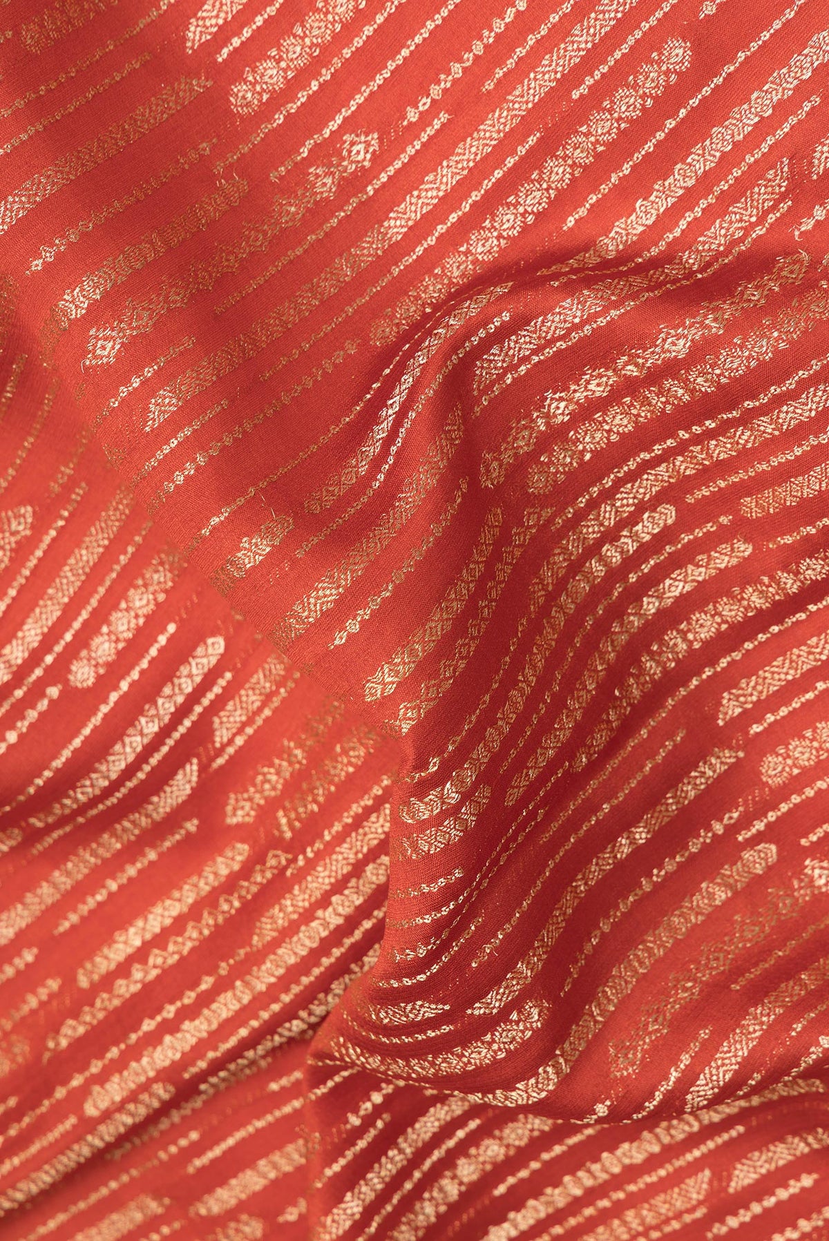 Close up of Pure Silk Rust Dual Tone Banarasi Georgette Saree with Zari Brocade on the body and Zari Border.  displaying folds
