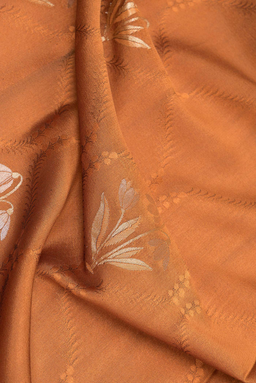 Close up of Rust Dual Tone Banarasi Georgette Saree with Jacquard With Zari Butta on the body and Zari Border.  displaying folds