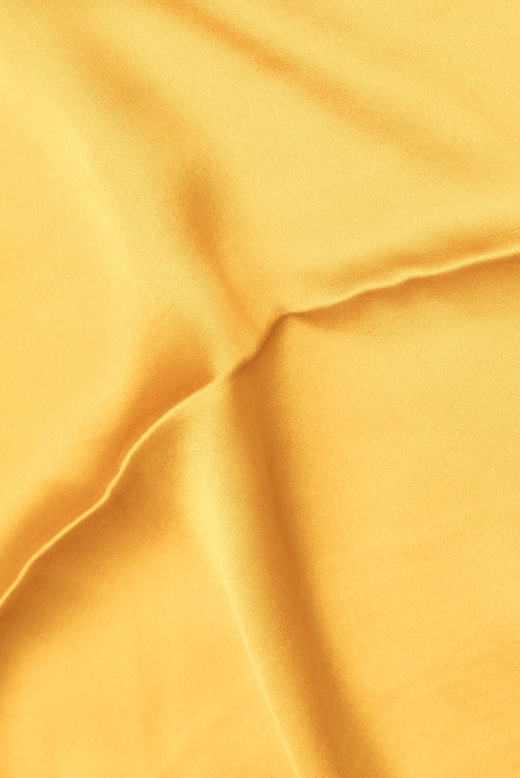 Close up of Mustard Satin Crepe Saree with Plain Body and Zari Border.  displaying folds