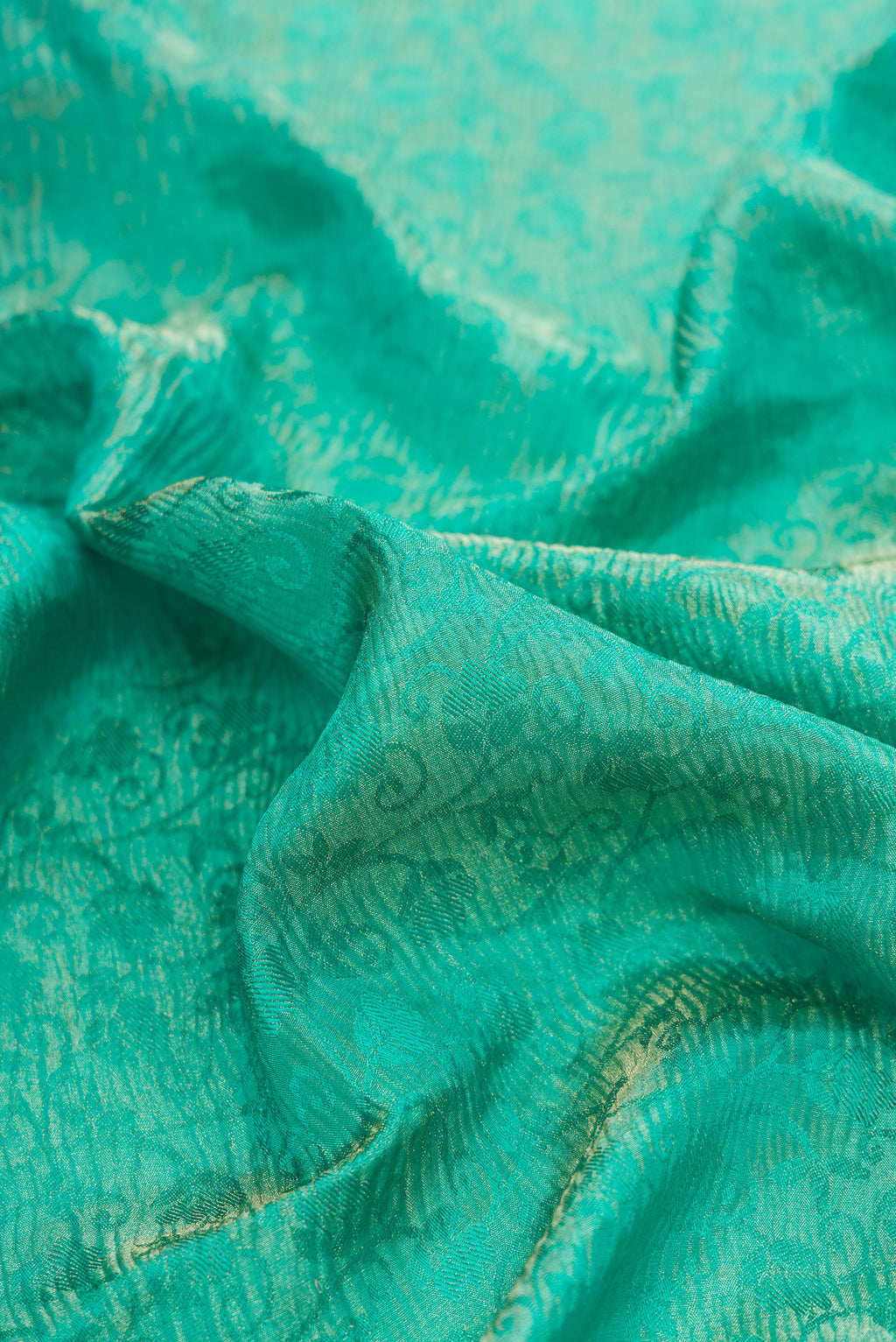 Close up of Sea Green Mysore Crepe Saree with Zari Brocade on the body and Zari Border.  displaying folds