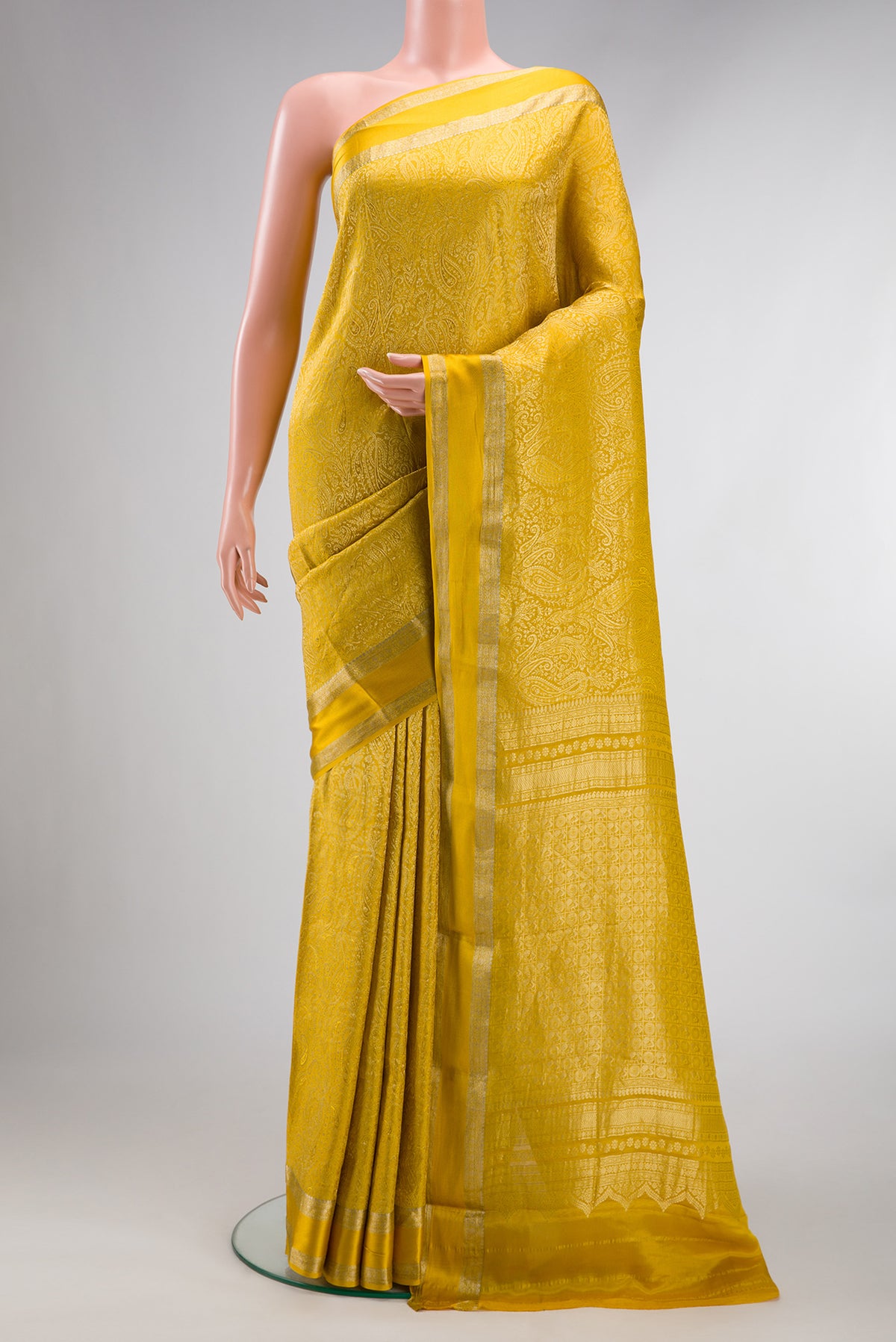 Mustard Mysore Crepe Saree with Zari Brocade on the body and Zari Border.  displayed on a mannequin