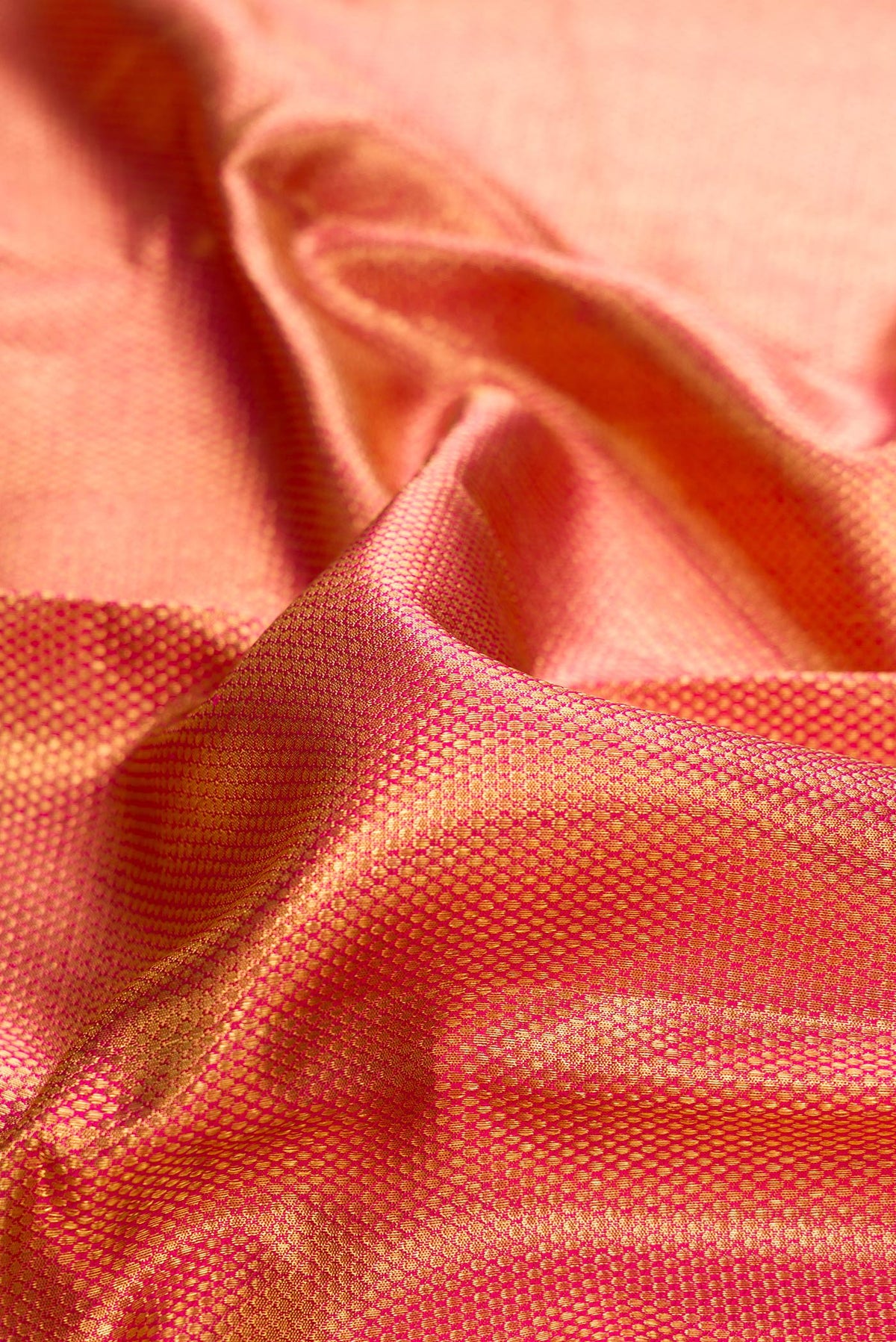 Close up of Pure Silk Pure Zari Pink Dual Tone Kanjivaram Tissue Saree with Zari Brocade on the body and Zari Border.  displaying folds