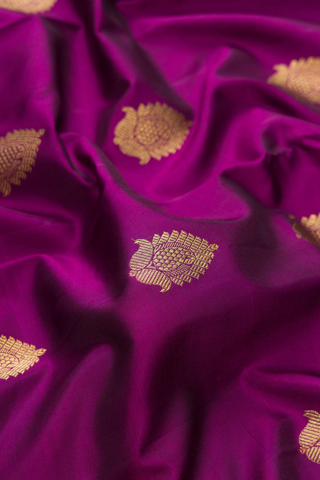 Close up of Pure Silk Pure Zari Purple Kanjivaram Saree with Zari Butta on the body and Zari Border.  displaying folds
