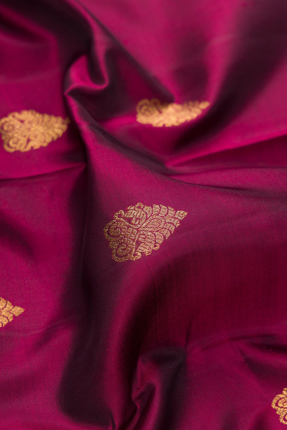 Close up of Pure Silk Pure Zari Maroon Kanjivaram Saree with Zari Butta on the body and Fancy Border.  displaying folds