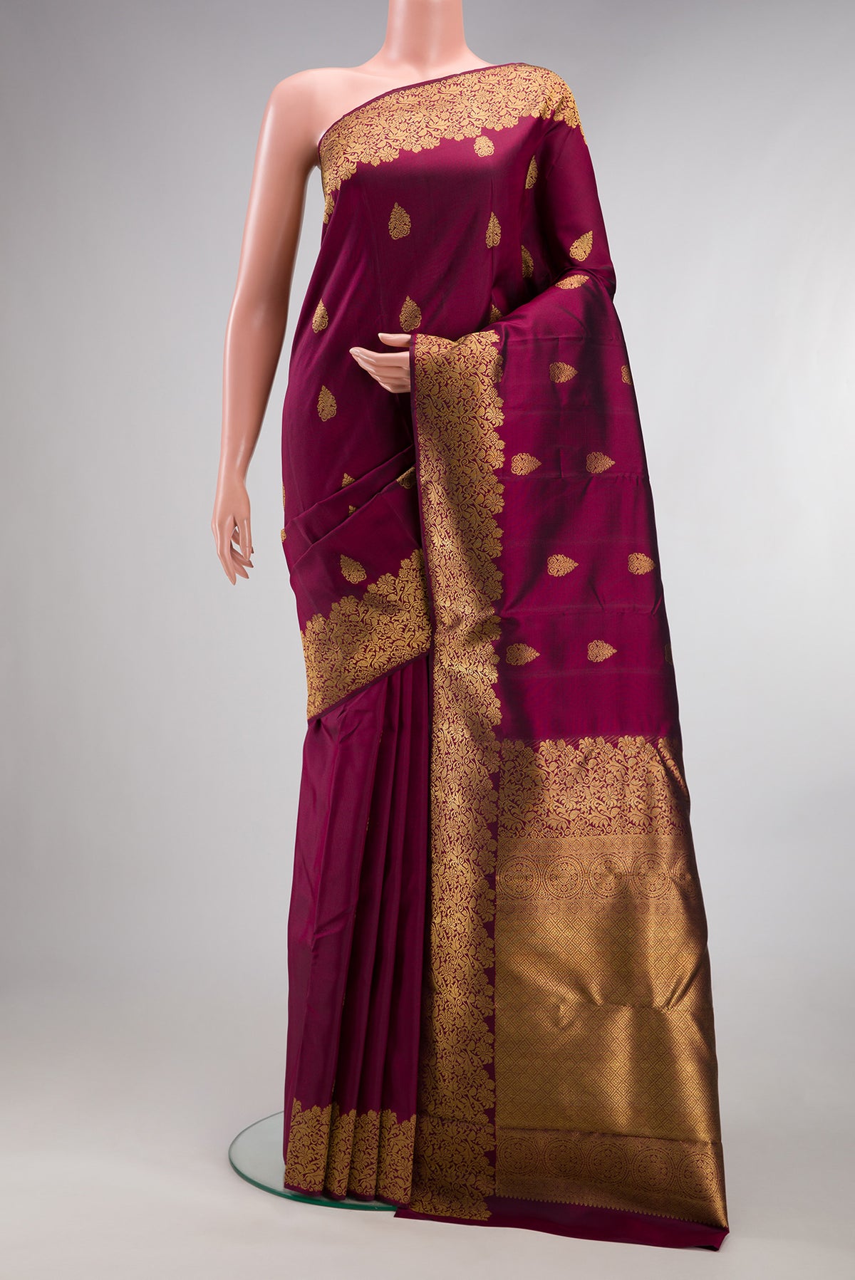 Pure Silk Pure Zari Maroon Kanjivaram Saree with Zari Butta on the body and Fancy Border.  displayed on a mannequin