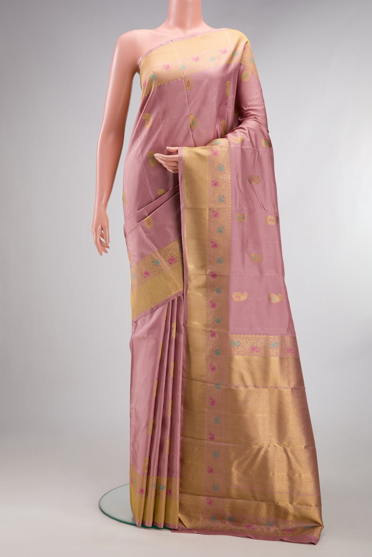 Pure Silk Pure Zari Peach Kanjivaram Saree with Zari And Thread Butta on the body and Fancy Border.  displayed on a mannequin
